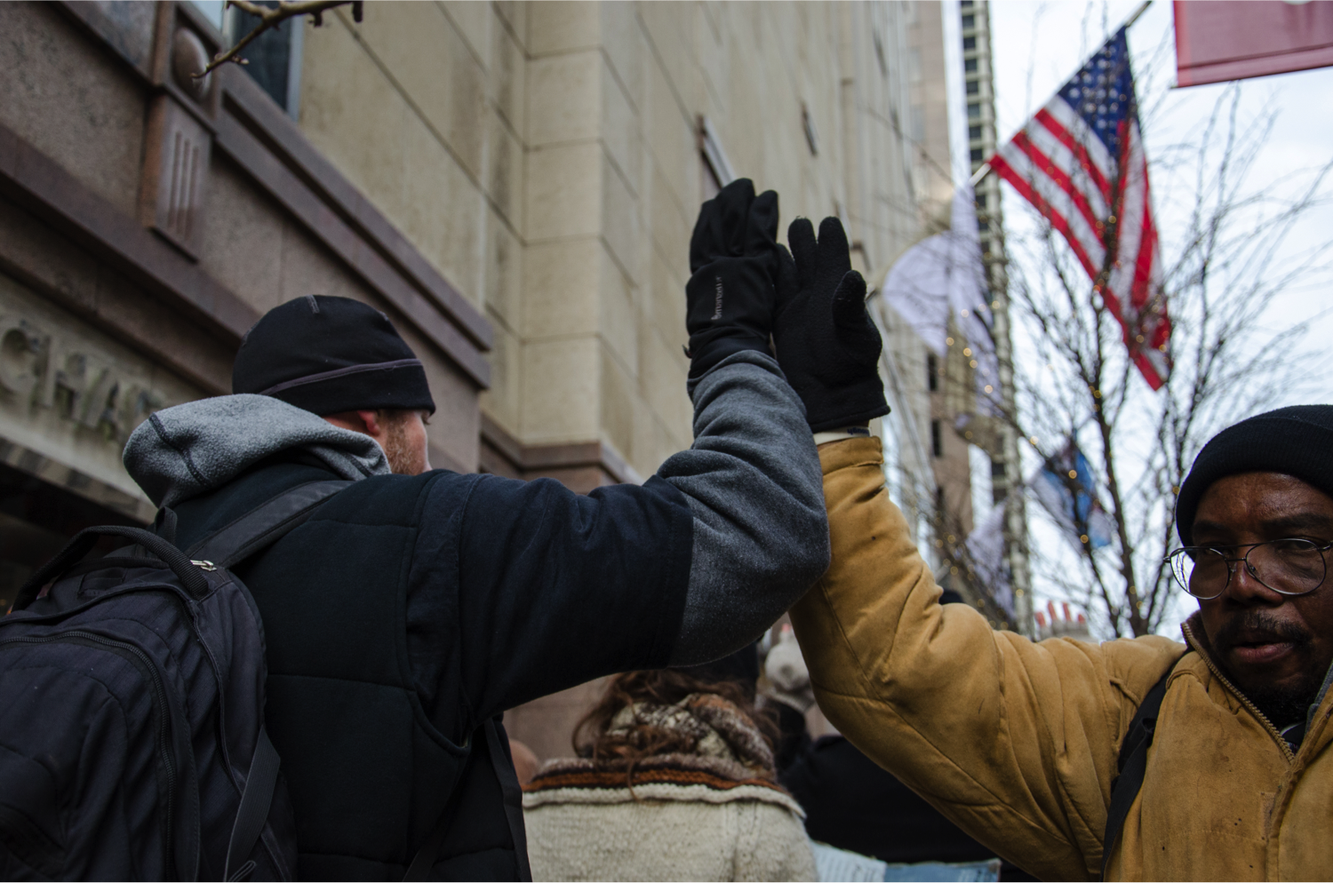 Protesters clap their hands with each other while marching on Michigan Avenue. (Jin Wu/Medill)