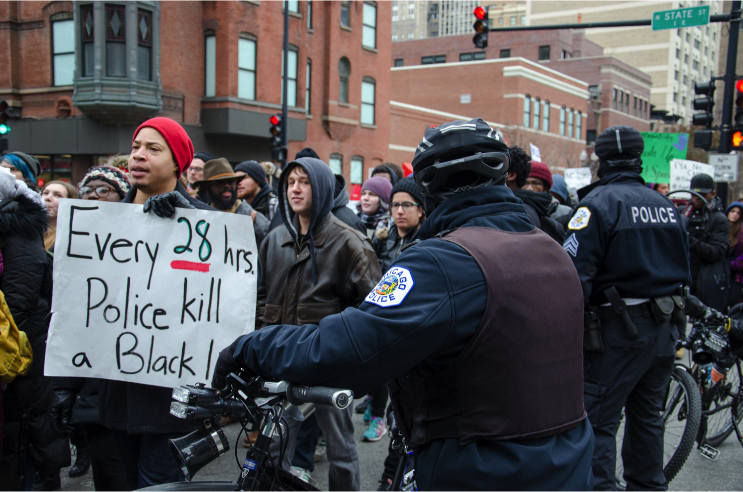 Chicago police escort the “Brown Friday” protesters all the way from Water Tower to Wicker Park, then to West Side. The police said they tried to protect the protesters from traffic, but the protesters thought the police were protecting the retailers. (Jin Wu/Medill)