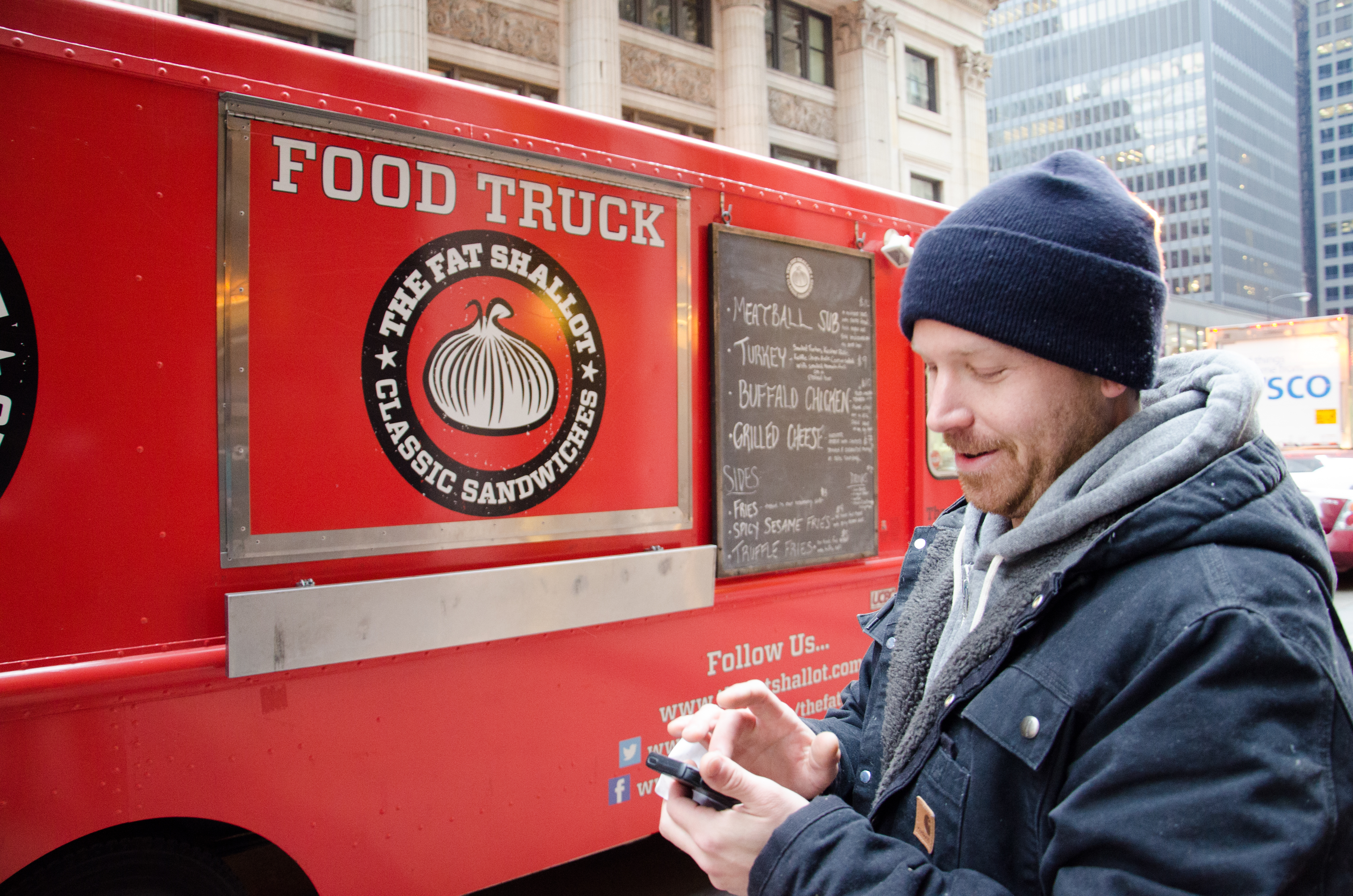 Sam Barron, one of the owners of the Fat Shallot, a food truck in Chicago, tweets about the location of his food truck Friday, Nov. 14, 2014, so that customers could find it during the lunch time. He runs the food truck with his wife Sarah. Because of the restrictive food truck regulations in Chicago, food trucks could not park within 200 feet of a restaurant including Starbucks and 7-11, so there are not many parking spots for food trucks inside the Loop. This spot near 215 S. Clark St. is one of the best spots in the city of Chicago. Barron arrived here around 6:30 a.m. to get a spot.